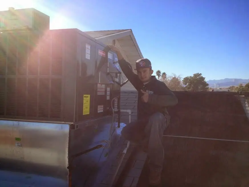 HVAC technician performing Air Duct Repair on a rooftop unit in Mascotte